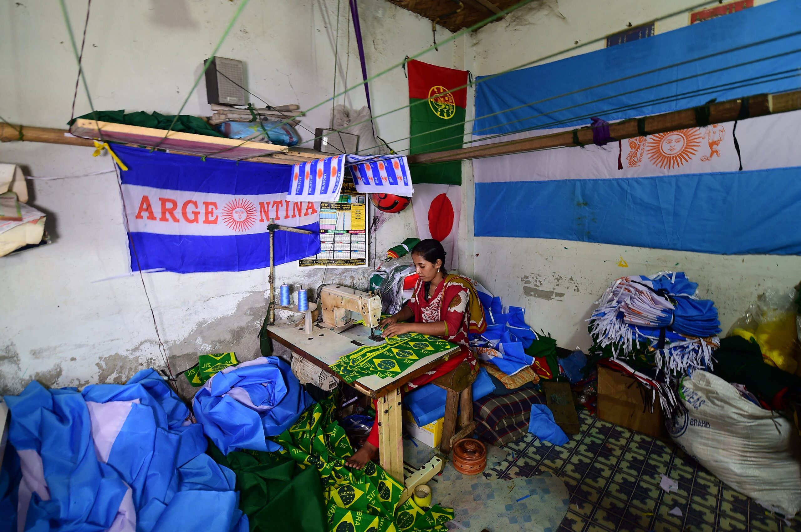 File: A Bangladeshi worker sewing flags for the World Cup football playing nations in Narayanganj, on the outskirts of Dhaka, ahead of the 2018 football World Cup