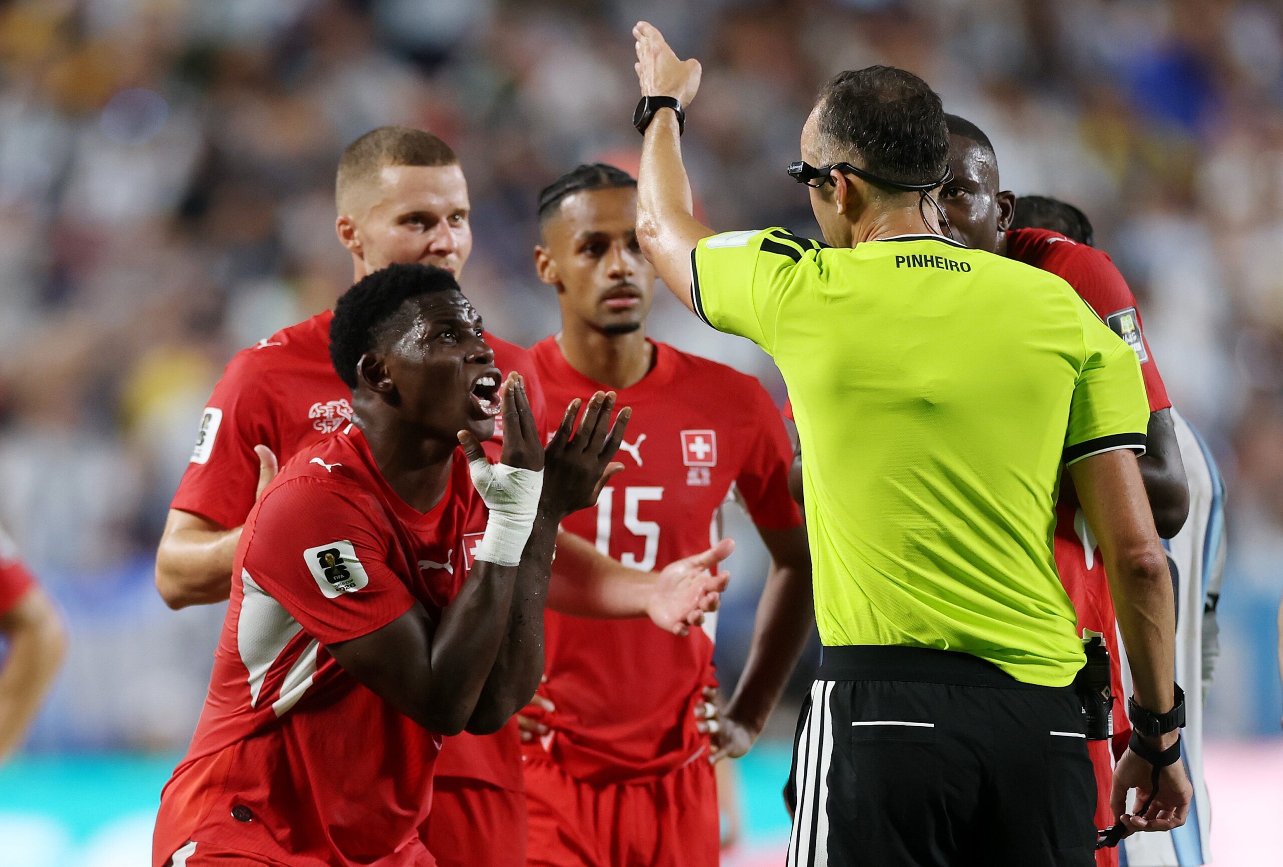 Breel Embolo argues with referee Joao Pinheiro after being shown a red card